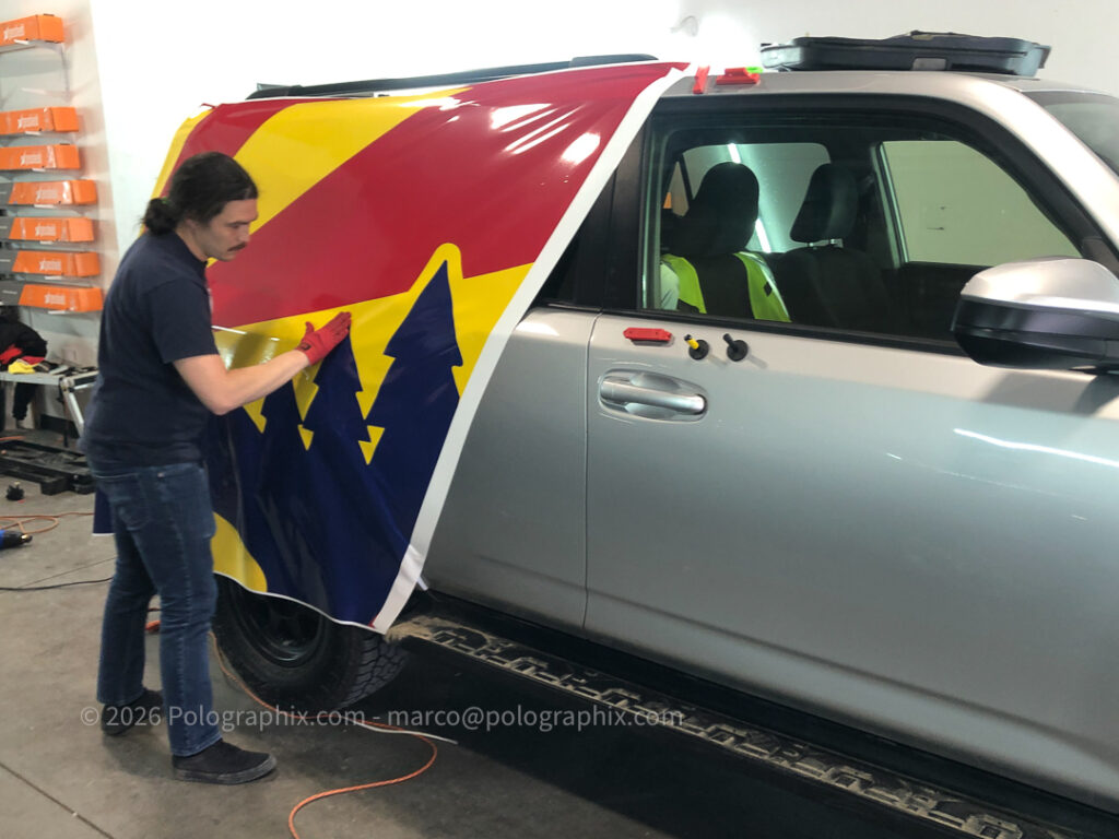 Alex of Luxe Auto Salon installing vinyl